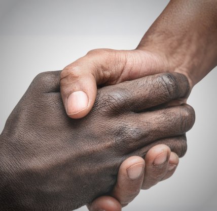 white hand and black hand clasped 